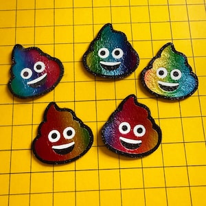 May include: Five rainbow-coloured poop-shaped patches with smiling faces and black outlines are arranged on a yellow grid. The patches have a metallic sheen, with colours blending from red to blue. Each patch has white eyes and a smiling mouth.