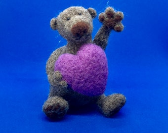 A Fuzzy Needle Felted Sad Brown Bear is trying to catch your attention by waving, so he can give you his Heart!