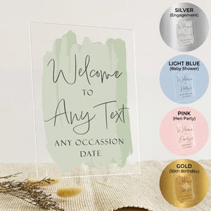 May include: A rectangular clear acrylic sign featuring a sage green painted brushstroke background. The text reads Welcome TO Any Text ANY OCCASSION DATE. Four circular colour swatches are displayed on the right in silver, light blue, pink, and gold.