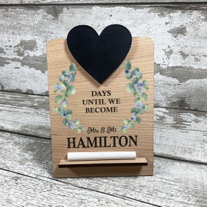 blue flowers eucalyptus design onto wooden wedding countdown, chalkboard heart for engagement countdown
days until we become mr and mrs