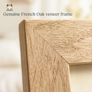 May include: Close-up of a light brown, textured, wooden picture frame corner. The frame is made of genuine French oak veneer. The text "Genuine French Oak veneer frame" is printed in black above the frame.