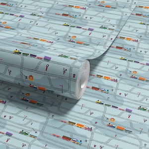 May include: A roll of wallpaper with a repeating pattern of toy trains on tracks. The trains are in various colours, such as yellow, red, and purple, set against a light blue background with railway signals and stations.