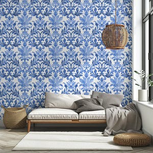 May include: Wallpaper featuring a repeating blue and white damask pattern with intricate floral and leaf motifs. The design covers the entire wall surface, showcasing a symmetrical, ornate style with varying shades of blue watercolor-like ink.