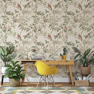 May include: A home office featuring a light wood desk and a yellow chair. The wall is adorned with wallpaper featuring a floral pattern and birds. Two potted plants add a touch of greenery to the space.