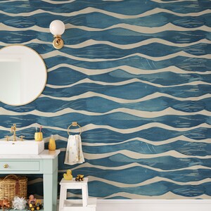 May include: Blue and beige wave pattern wallpaper in a bathroom setting. The wallpaper is the focal point, with a repeating design of stylized waves. A round mirror, a light fixture, and a small sink are also visible.
