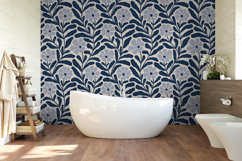 May include: A modern bathroom with a white, oval-shaped bathtub. The wall behind the tub features a floral pattern in navy blue and gray. The floor is made of wood. A wooden shelf with towels and toiletries is on the left.