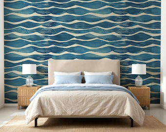May include: A bedroom scene featuring a bed with a beige headboard, light blue pillows, and a beige comforter. The wall behind the bed is adorned with a blue and white wave pattern wallpaper. Wicker bedside tables with lamps complete the room's decor.
