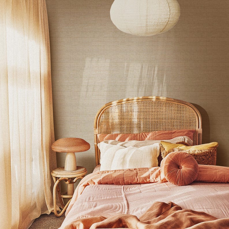May include: A bedroom scene featuring a bed with a woven headboard, adorned with pink and peach bedding and pillows. A small mushroom-shaped side table and a paper lantern hang from the ceiling. The room has a warm, inviting atmosphere.