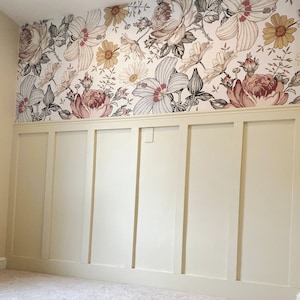 May include: A white wall with wainscoting and a floral wallpaper border. The wallpaper features a variety of flowers in shades of pink, red, and yellow.