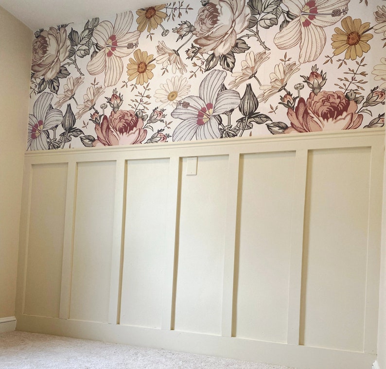 May include: A white wall with wainscoting and a floral wallpaper border. The wallpaper features a variety of flowers in shades of pink, red, and yellow.