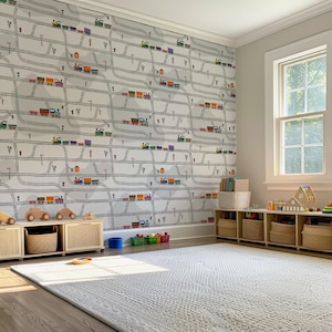 May include: A child's playroom with a train-themed wallpaper. The wallpaper features colorful trains on gray tracks. Wooden toy storage units and a white rug are in the room. A window lets in natural light.