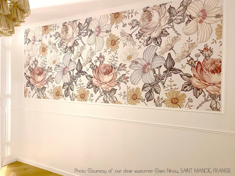 May include: A white wall with a floral wallpaper border featuring a repeating pattern of pink, brown, and yellow flowers. The wallpaper border is approximately 10 inches tall.