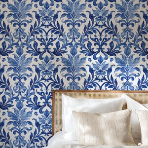 May include: Wallpaper featuring a repeating blue and white damask pattern with intricate floral and leaf motifs. The design consists of symmetrical, flowing shapes in various shades of blue against a solid white background, creating a continuous print.