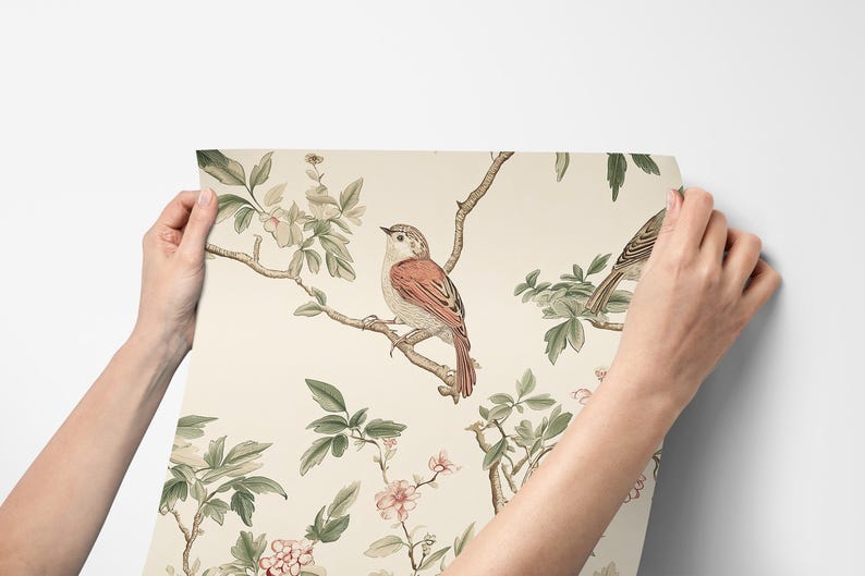 May include: A cream-coloured wallpaper with a repeating pattern of delicate pink flowers, green leaves, and brown birds. The birds are perched on branches and have a realistic, detailed design.