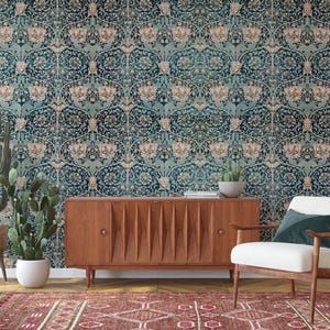 May include: A room interior featuring a teal floral wallpaper, a wooden cabinet, a white armchair, and a patterned rug. Potted cacti and succulents add a natural touch. The overall aesthetic is vintage-inspired with a modern twist.