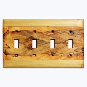 Könnte beinhalten: Eine Holz-Lichtschalterplatte mit vier Öffnungen für Lichtschalter. Die Platte ist aus Ahornholz mit einer natürlichen Holz-Oberfläche. Das Holz hat eine einzigartige Maserung mit braunen, orangefarbenen und gelben Tönen.