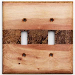 May include: A wooden double light switch cover with a natural wood grain pattern. The cover features two toggle switch openings and four screw holes. The design incorporates a darker, textured wood band across the center, adding visual interest to the light fixture.
