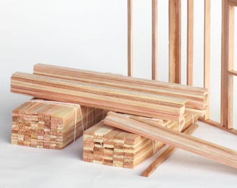 May include: A close-up of a stack of wooden planks, likely cedar, bundled together with twine. The planks are a light brown color with a natural wood grain. The planks are arranged in a neat stack, with the ends of the planks visible. The planks are likely for use in construction or woodworking projects.