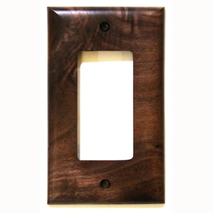May include: A rectangular, dark brown wooden light switch cover with a single rectangular opening. The cover has a glossy finish and two small, dark screws. The wood grain is visible, adding texture to the design.