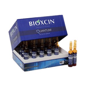 May include: A blue box of BIOXCIN Quantum Bio-Activ Serum ampoules. The box is open, revealing multiple small, brown glass vials. The BIOXCIN logo and product information are printed on the box. Several ampoules are outside the box.