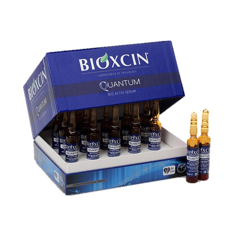 May include: A blue box of BIOXCIN Quantum Bio-Activ Serum ampoules. The box is open, revealing multiple small, brown glass vials. The BIOXCIN logo and product information are printed on the box. Several ampoules are outside the box.