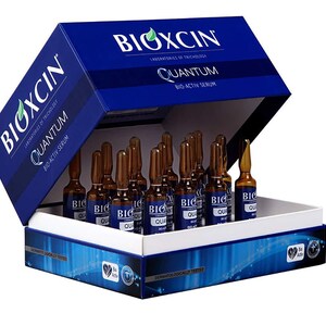 May include: A blue box with the brand name "BIOXCIN" and product details. Inside, multiple small brown vials are visible, labeled "QUANTUM BIO-ACTIV SERUM". The box has a white interior and a blue lid, with additional text and logos.