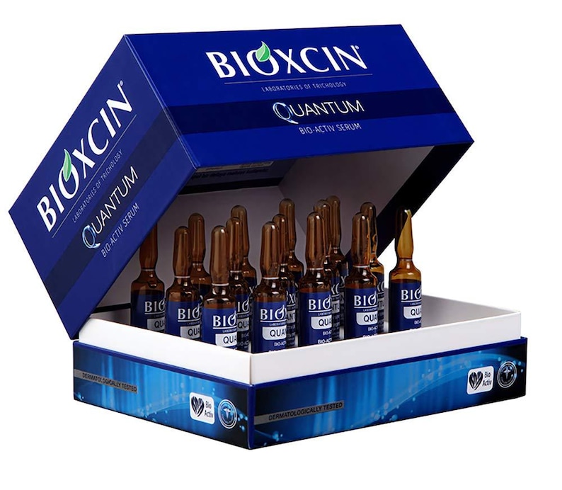 May include: A blue box with the brand name "BIOXCIN" and product details. Inside, multiple small brown vials are visible, labeled "QUANTUM BIO-ACTIV SERUM". The box has a white interior and a blue lid, with additional text and logos.