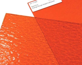 Puede incluir: Una lámina de vidrio catedral naranja de textura rugosa y laminada. Una etiqueta blanca en la esquina superior contiene el texto: SP 171RR, Spectrum, Orange Rough Rolled Cathedral y el logotipo de Bradstreet Glass.