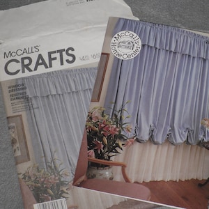 May include: Two McCall's Crafts sewing pattern envelopes. One envelope is open, revealing the pattern inside. The patterns are for window dressing, with a picture of a light blue curtain with a ruffled top. The McCall's Home Center logo is visible.
