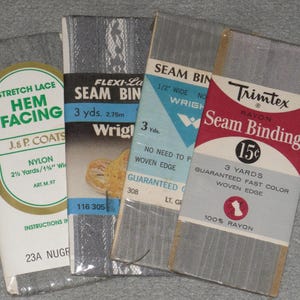 May include: An assortment of vintage sewing notions, including gray seam binding and hem facing. The packages feature text such as "Stretch Lace Hem Facing" and "Seam Binding." The items are packaged in various colors, including red, white, and blue.