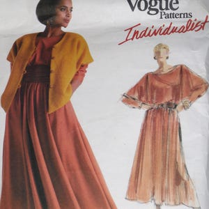 May include: Vogue Patterns Individualist sewing pattern featuring two dress designs. One dress has a long skirt and a short-sleeved mustard yellow jacket. The other dress has a cape-like top and a long skirt. The pattern is on a white background.