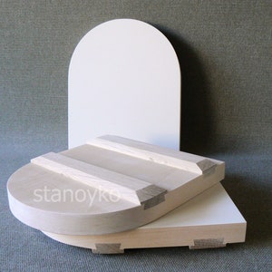 May include: Two wooden bowls, one stacked on top of the other, with a white background behind them. The top bowl is round and has a slightly curved edge. The bottom bowl is rectangular and has a flat edge. Both bowls are made of light-colored wood and have a smooth finish.