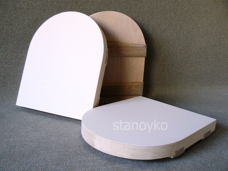 May include: Three wooden, unfinished, round-shaped, blank canvases. The canvases are different sizes and are stacked on top of each other. The largest canvas is white and the two smaller canvases are natural wood color.