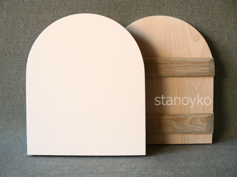 May include: Two wooden arched shapes, one painted white and the other with a natural wood finish. The natural wood shape has two horizontal wood strips across the center.