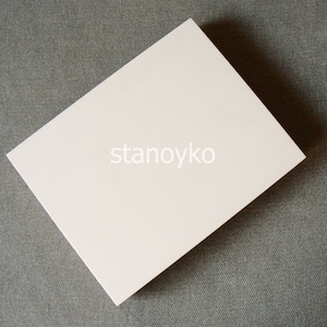 May include: A blank white card on a gray textured surface. The card is rectangular and has a smooth, matte finish.