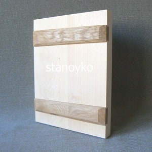 May include: A light wood panel with two horizontal strips of darker wood. The panel has the word "stanoyko" printed on it.