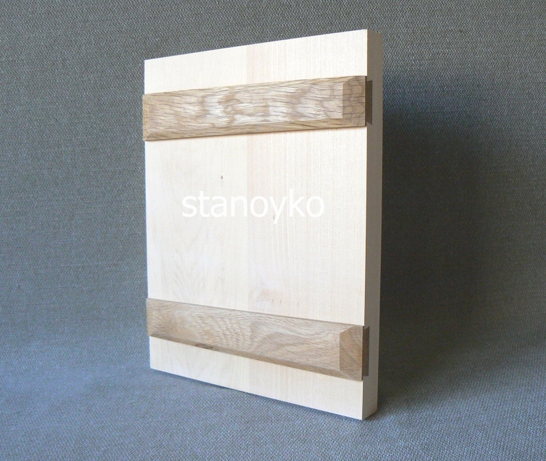 May include: A light wood panel with two horizontal strips of darker wood. The panel has the word "stanoyko" printed on it.