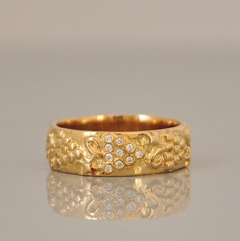 Puede incluir: Un anillo de banda de oro con un dise&ntilde;o texturizado y un grupo de peque&ntilde;os diamantes.