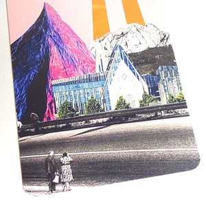 May include: A collage of a pink, blue and white mountain scene with a city in the foreground. The city has a large building with a glass facade and a road with two people walking on it.