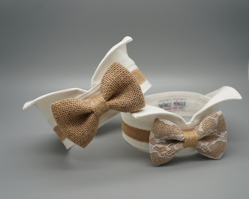 May include: Two white fabric dog collars with a bow tie. One bow tie is made of burlap and the other is made of lace.