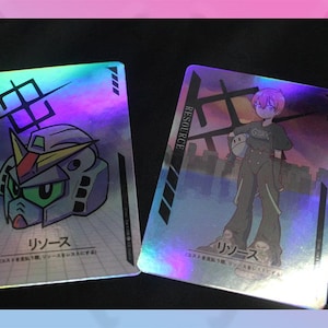 May include: Two holographic trading cards with Japanese text and illustrations. One card features a robot head, the other a character in a jumpsuit. Both cards have the word "RESOURCE" printed vertically.