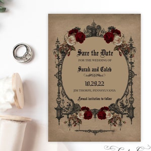 May include: Save the Date card with a vintage, gothic design. The card features a black ornate frame with red and white roses, and the text "Save the Date" for the wedding of Sarah and Caleb on 10.29.22 in Jim Thorpe, Pennsylvania. The card also includes the text "Formal invitation to follow".