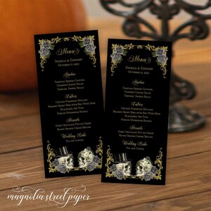 May include: Two black wedding menu cards with gold accents and a skull and roses design. The menu lists starters, entrees, desserts, and wedding cake. The text on the cards reads "Menu", "Angela & Edward", "October 13, 2023", "Starters", "Entree", "Desserts", "Wedding Cake", "Tea and Coffee".