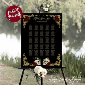 May include: Black wedding seating chart with gold ornate frame and red roses. The chart has the text "Find Your Seat" and "Angela & Edward" with the date "October 15, 2022". The bottom of the chart features two skulls with top hats and flowers.