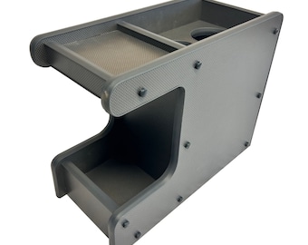 May include: A black, textured, plastic car organizer with two compartments and a cup holder. The organizer has a unique design with a raised lip around the top and bottom compartments.