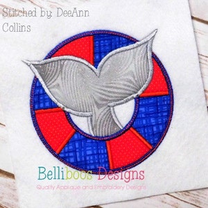 Puede incluir: Diseño bordado de una cola de ballena dentro de un salvavidas rojo y azul. El diseño está bordado con una tela texturizada e incluye el texto "Stitched by DeeAnn Collins" y "Belliboos Designs".