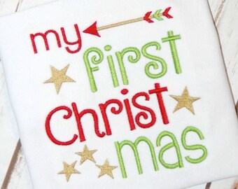 May include: White onesie with the text "my first christmas" in red and green embroidery. The text is decorated with gold stars and an arrow.