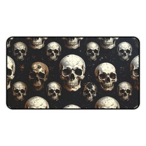 May include: A rectangular black desk mat with a repeating pattern of white and brown skulls. The skulls are of varying sizes and are set against a dark background with small, scattered details.