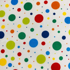 May include: White fabric with a repeating pattern of colorful polka dots in various sizes. The dots are in shades of red, orange, yellow, green, and blue. The fabric has a textured appearance.