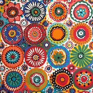 May include: A vibrant fabric featuring a repeating pattern of colorful, circular floral designs. The flowers are in shades of red, orange, yellow, blue, and green, with white and black accents, set against a white background. The design is reminiscent of a bohemian or retro style.
